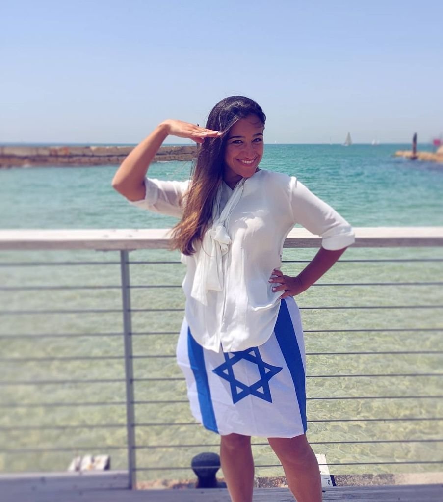 Rivka mannequin tsniout en haut blanc et jupe en drapeau israélien.