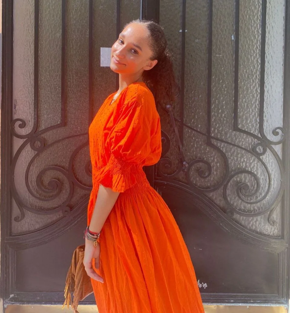 Shirel modèle tsniout en robe en orange.