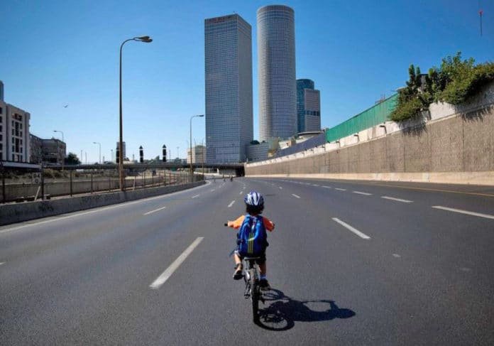autoroute où il y a un enfant à vélo avec gratte-ciel à coté de l'autoroute